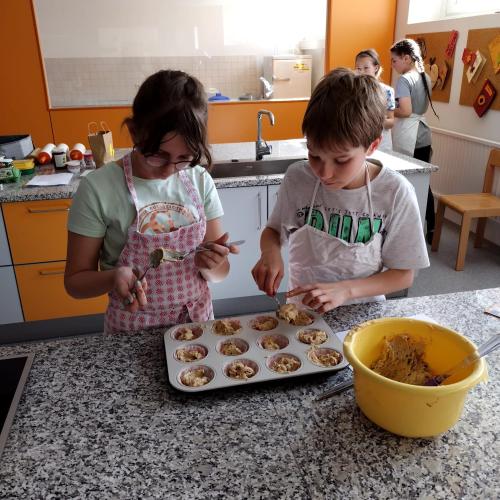 Schülerin und Schüler beim Backen von Märchen-Muffins